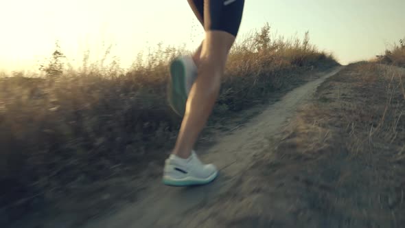 Running Man In Uphill At Sunset Slow Motion.Runner Marathon Jog On Trail.Runner Man Fit Athlete Legs