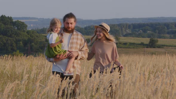 Caucasian Happy Family Walking in Wheat Field Outdoors