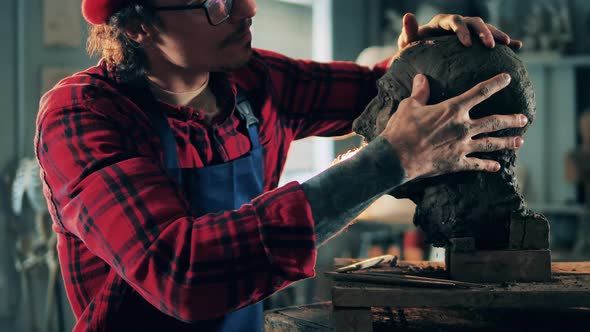 Male Artist Finished Molding a Head Out of Clay