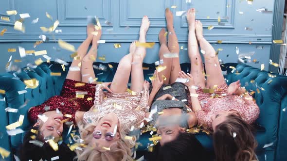 Bachelorette Party Glamour Females Lie on the Couch Legs Up Golden Confetti Flying in the Air Luxury