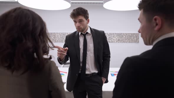 Young Confident Male CEO Scolding Employees in Office Indoors in Slow Motion