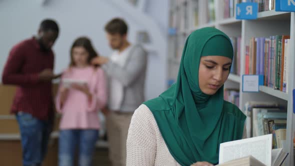 Muslim Female Student Reading a Book in Library