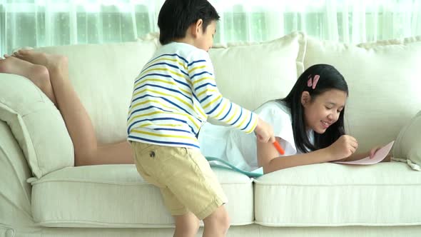 Asian Children Drawing Together In Living Room