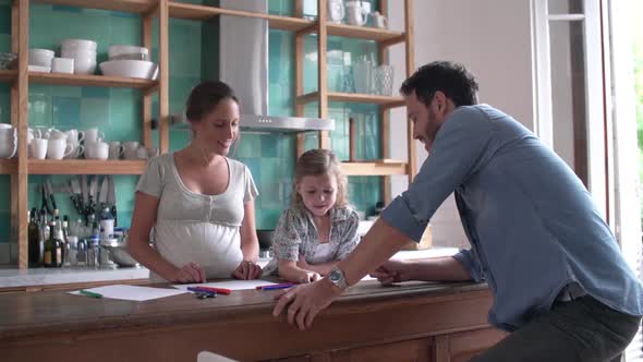 Parents coloring with young daughter in the kitchen