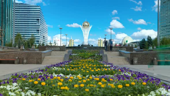 Flowers on Nurzhol Boulevard with Baiterek on Background Timelapse Hyperlapse
