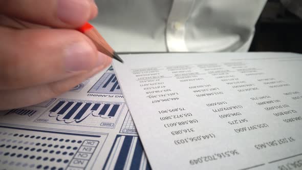 Accountant Analyzing Business Marketing Data on Paper Dashboard at Office Table