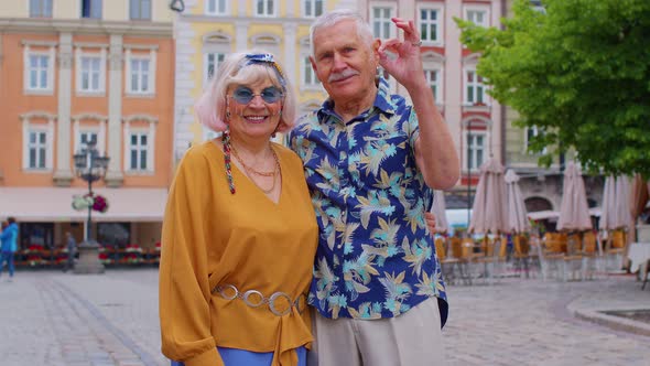 Elderly Stylish Couple Tourists Man Woman Looking Approvingly at Camera Showing Ok Gesture Like Sign