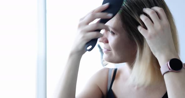 Young Woman Combs Hair and Screams From Falling Out