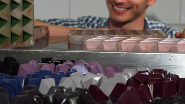 Cheerful Confectioner Examining Handmade Candy at His Kitchen