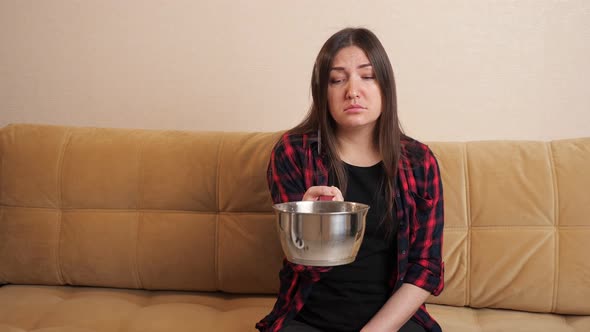 Sad Woman Collects Water Flowing Down From Ceiling on Sofa