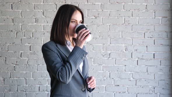 Smiling Company Manager in Blouse and Costume Drinks Coffee