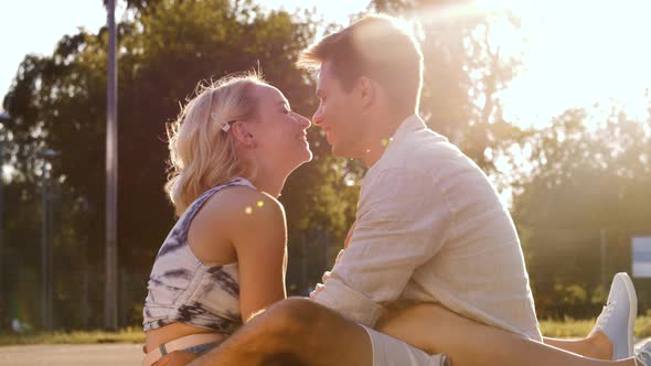 Happy Couple Kissing on Basketball Playground