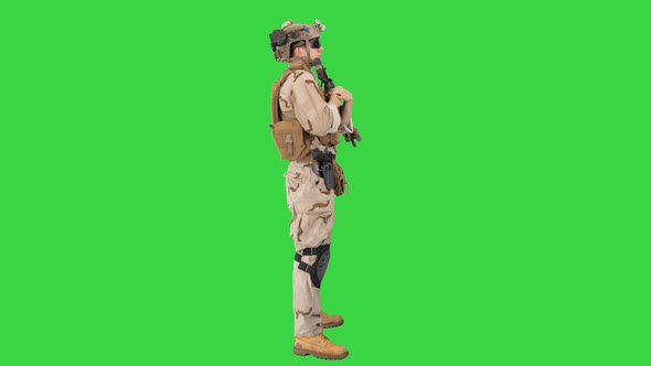 Soldier with Machine Gun Standing on a Green Screen, Chroma Key.