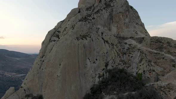 Flying over the Pena de Bernal monolith at sunset in Mexico -Aerial