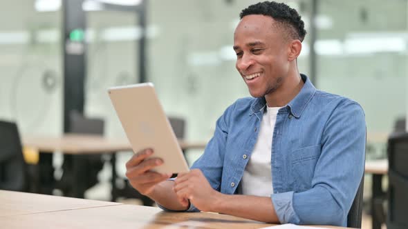 Casual African Man Doing Video Chat on Tablet in Office