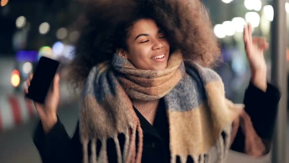 Woman having fun and dancing at the evening street.