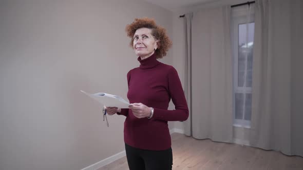 Caucasian Mature Woman Inspecting an Empty Apartment Before Signing a Lease Agreement