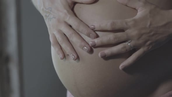 Pregnant Woman Make Heart Shape with Hand Symbolic in Beautiful Light