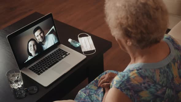 Cheerful Old Eldery Woman Talking Camera Video Conference on Laptop Calling From Home with Family