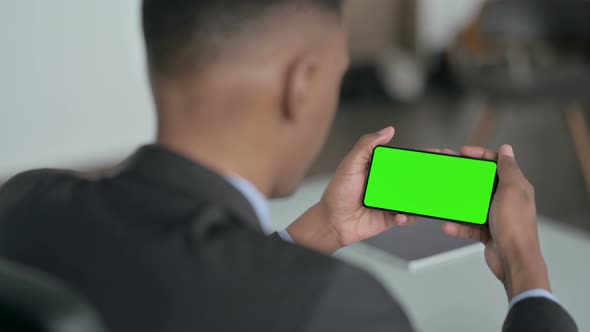 Rear View of African Businessman Looking at Smartphone with Chroma Screen