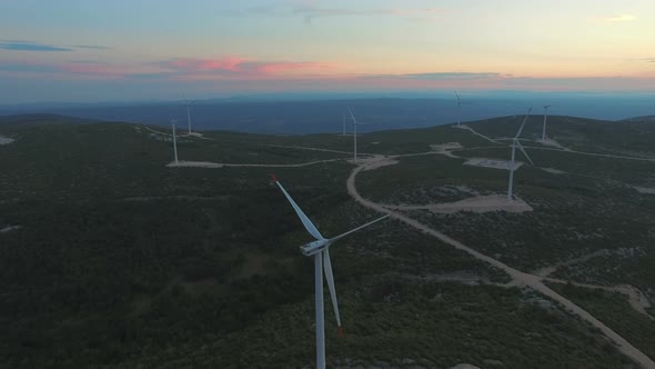 Aerial view of eight windmills for the production of electric energy, at sunset