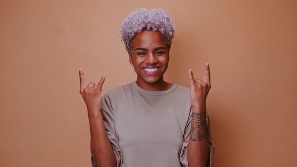 Young African American Woman Rock and Roll Lover Demonstrates Goat Gesture