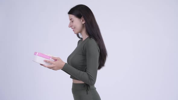 Profile View of Happy Young Beautiful Woman with Gift Box Being Taken Away