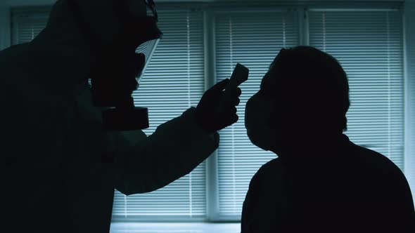 Clinical Doctor Checks Patient's Temperature. Coronavirus, Covid-19 Infected Patient During Test in