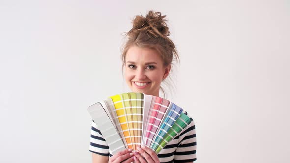 Portrait of smiling woman showing paint swatches 