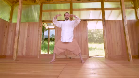 Bearded Caucasian Man Wearing White Clothes To Practice Concentration and Breathing Before