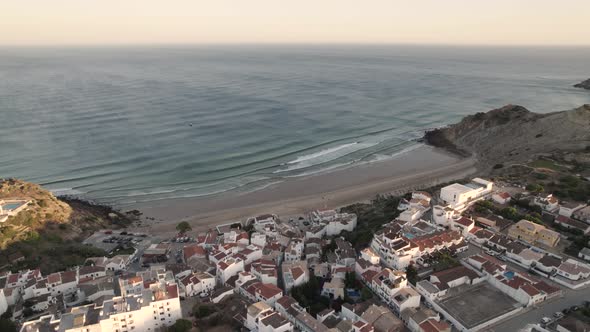 Burgau town sun kissed with soft sunlight, Algarve.  Waves washing on sand beach