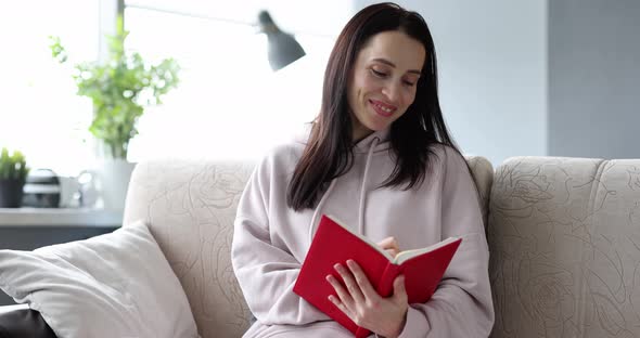 Smiling Woman Writing Diary Notes While Sitting on Sofa at Home