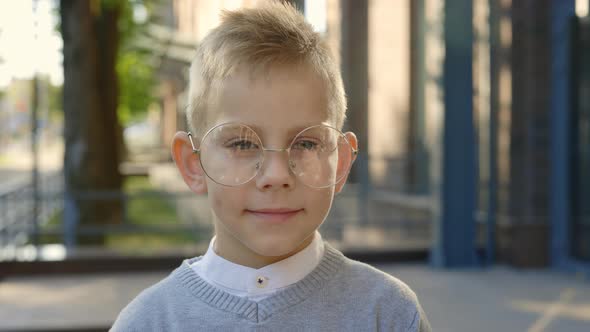 Close Up View of the Schoolboy Stabding Looking at the Camera Wearing Glasses and Smiling