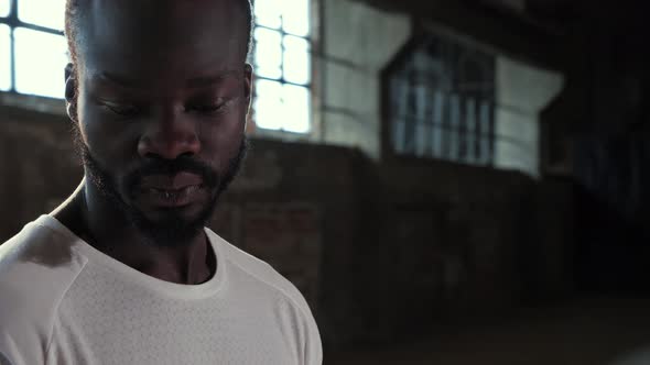 Portrait of black man in white t-shirt looking at camera indoors