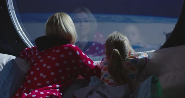 Mother and Daughter Enjoying View From Spaceship