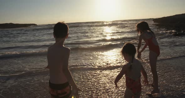Three kids playing on the beach together