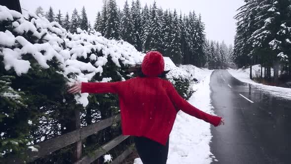 Happy Girl Running Along the Snowy Trees