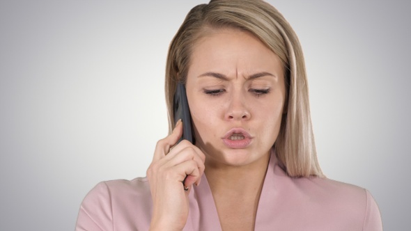 Smiling woman talking on the phone on gradient background.