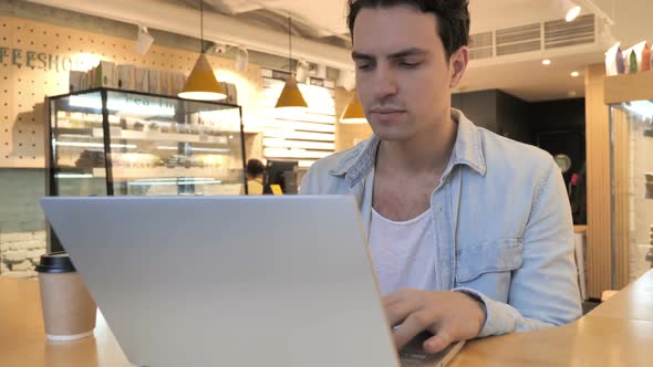 Tired Young Man Working in Cafe on Laptop Neck Pain