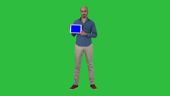 Arab man showing blank tablet screen on a Green Screen, Chroma Key