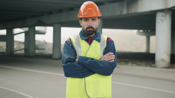 Slow Motion Portrait of Field Engineer Standing in Industrial Area with Arms Crossed