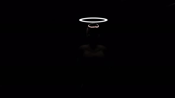 Silhouette of walking man with flashing halo in darkness