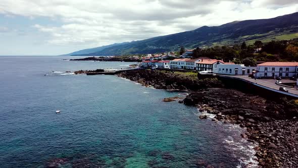 Flying towards Sao Roque do Pico village in Pico Island. Landscape shot of the rocky coast. Azores,