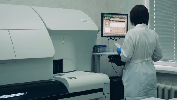 Lab Expert Is Managing a Biochemical Analyzer Through the Computer