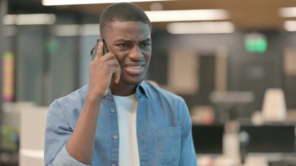 Young African American Man Getting Angry on Phone Call