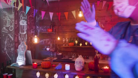 A Bar Decorated for Halloween and Young People in Scary Outfits Are Dancing