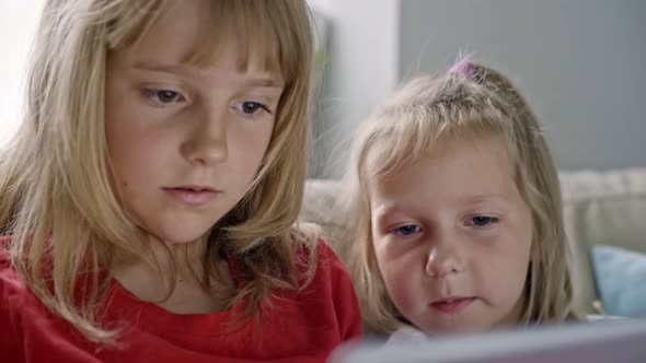 Cute Little Sisters Playing on Tablet