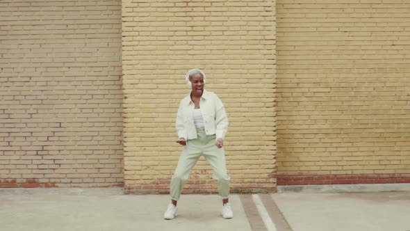 Slow motion shot of woman listening to music and dancing