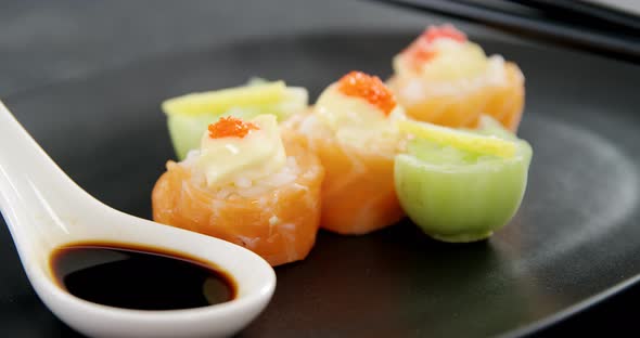 Sushi served on plate with chopsticks and sauce