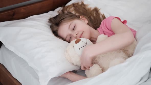 Child with Teddy Bear in the Bed